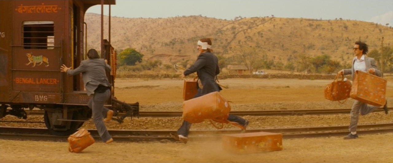 3 men in outback carrying suitcases and running to jump on old fashioned train