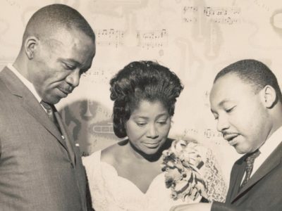 black and white photo showing Mahalia Jackson centre with Martin Luther King and one other